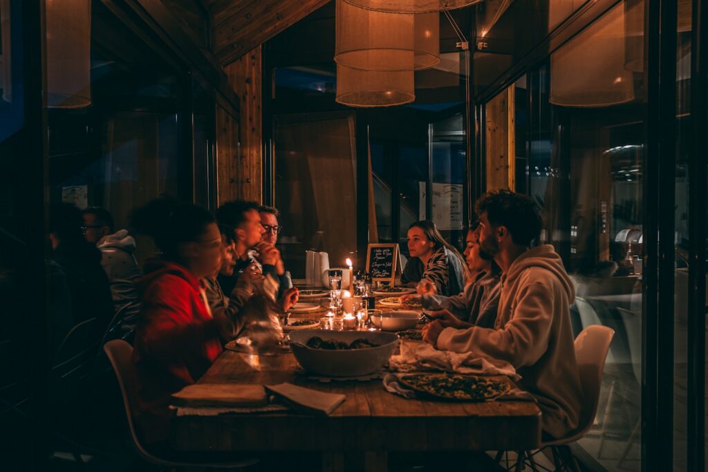 Friends sharing an evening meal in a warm restaurant