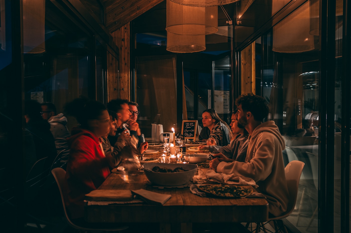 Friends sharing an evening meal in a warm restaurant